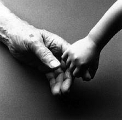 Child's hand holding finger of an old man